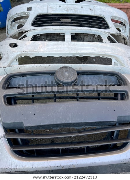 junk yard,\
Damaged old car bumpers and parts in dent repair technician service\
for vehicles. repair and remove dents on body and prepare surface\
for spray painting in car\
service