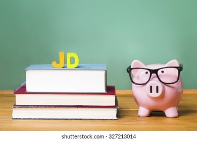 Juris Doctor Law Degree Theme With Pink Piggy Bank With Chalkboard In The Background As Concept Image Of The Costs Of Education