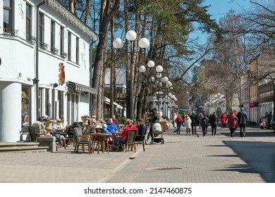Jurmala. Latvia. April 18, 2022. Architecture of Jurmala has been preserved since the beginning of the 20th century. People walking along Jomas Street on sunny spring day. Outdoor cafeteria.