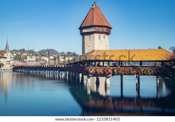 Just a 5\
minutes walk away from Port and Trainstation you will find the most\
famous Chapel Bridge. An adorable old bridge crossing Reuss. Behind\
the bridge you can already see the\
alps.