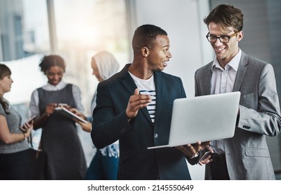 Just Another Busy Average Day In The Office. Shot Of A Group Of Young Cheerful Businesspeople Browsing On Digital Devices While Working Together In The Office At Work.