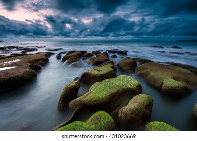 Just before a heavy storm hit Kudat sunset seascape with rocks boulders. Image contain soft focus and blur.