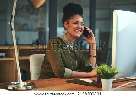 Just calling to let you know Ill be late. Shot of an attractive young woman using her cellphone in the office.