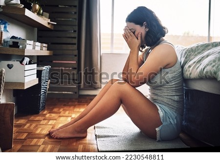 I just cant get over him. Full length shot of an attractive young woman looking depressed while sitting on the floor in her bedroom at home.