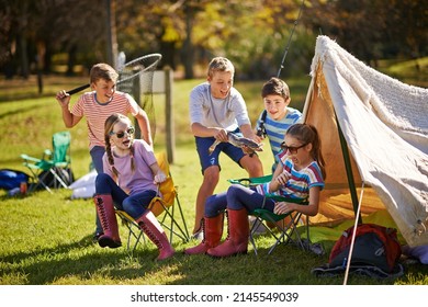 Just chilling at the campsite. Shot of a group of young friends hanging out at their campsite. - Shutterstock ID 2145549039