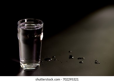 Just a glass of water on a dark background