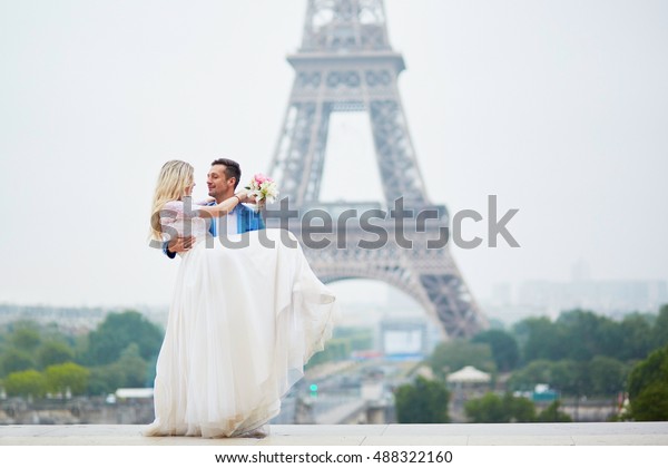 Just married couple near the\
Eiffel tower on their wedding day. Bride and groom in Paris,\
France