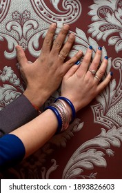 Nur verheiratet internationales multirassisches Paar Hände mit Ringen auf Tapete mit Monogramm, indianischer Ehemann und europäische Ehefrau, verschiedene Hautfarben 
