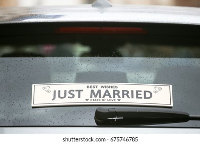 A Just Married Sign On The Back Window Of A Car.