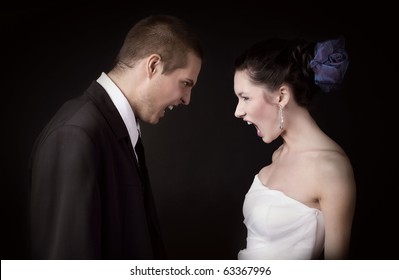 Just married young caucasian couple arguing and shouting at each other, on black background isolated
