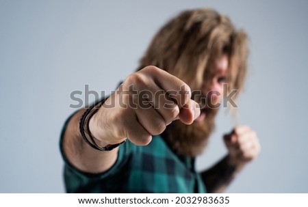 just one hit. bearded man punching with fist. boxing concept. negative human emotions. anger and aggression. angry mature brutal hipster fighting. knockout. casual fashion style