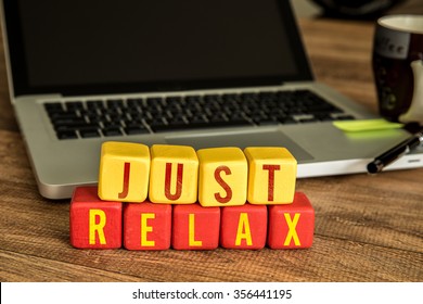Just Relax written on a wooden cube in a office desk