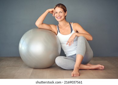 Just roll with it. Shot of a sporty young woman sitting next to her fitness ball. - Powered by Shutterstock