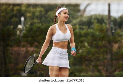 Just serve it. Shot of an attractive young woman playing tennis outside. - Powered by Shutterstock