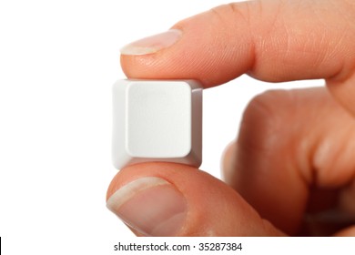 Just a small empty key from a computerkeyboard between fingers, white background