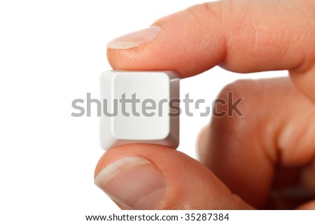 Just a small empty key from a computerkeyboard between fingers, white background