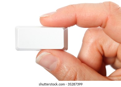 Just a small empty rectangular key from a computerkeyboard between fingers, white background
