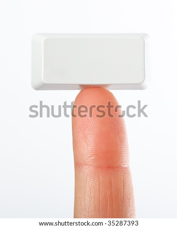 Just a small empty rectangular key from a computerkeyboard on fingertip, white background