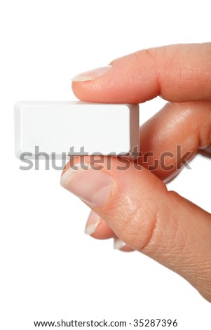 Just a small empty rectangular key from a computerkeyboard between fingers vertical, white background
