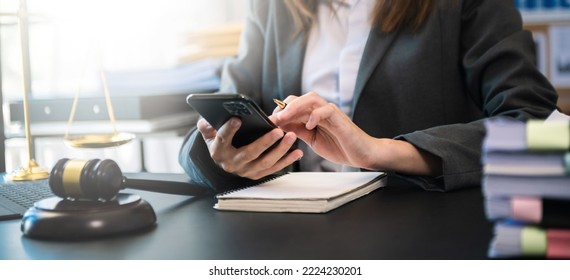 justice and law concept. asian woman lawyer working and judge in a courtroom the gavel, working with tablet and laptop and digital tablet computer on white table  - Shutterstock ID 2224230201