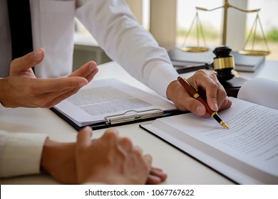 Justice and Law concept. Legal counsel presents to the client a signed contract with gavel and legal law or legal having team meeting at law firm in background - Powered by Shutterstock