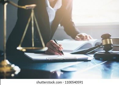 Justice and Law concept. Legal counsel presents to the client a signed contract with gavel and legal law or legal having team meeting at law firm in background - Shutterstock ID 1100540591
