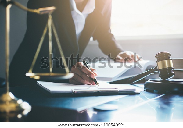 Justice and Law concept. Legal\
counsel presents to the client a signed contract with gavel and\
legal law or legal having team meeting at law firm in\
background