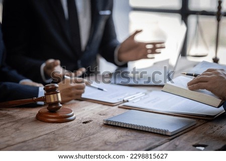 justice and law concept. male lawyer working in an office. Legal law, advice, and justice concept. The client is bringing the documents to clarify the law to the lawyer at the prosecutor's office.
