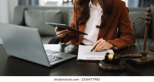 justice and law concept.Male judge in a courtroom  the gavel, working with smart phone and laptop and digital tablet computer on black desk - Shutterstock ID 2336477985