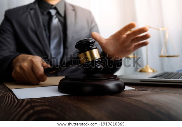 justice and law concept.Male judge in a
courtroom on wooden table and Counselor or Male lawyer working in
office. Legal law, advice and justice
concept.