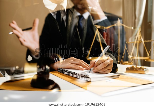 justice and law concept.Male judge in a\
courtroom on wooden table and Counselor or Male lawyer working in\
office. Legal law, advice and justice\
concept.