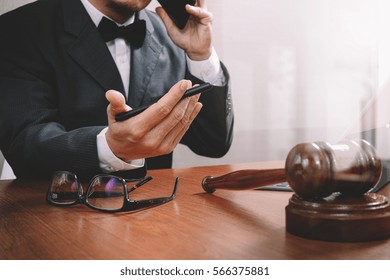 Justice And Law Concept.Male Lawyer In Office With The Gavel,working With Smart Phone,digital Tablet Computer Docking Keyboard,brass Scale,on Wood Table,filter Effect