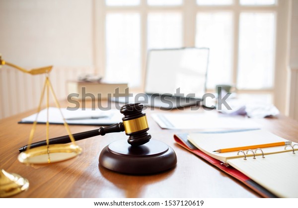 Justice law Scales and books and wooden\
gavel tool on desk in  Lawyer\
office.concept