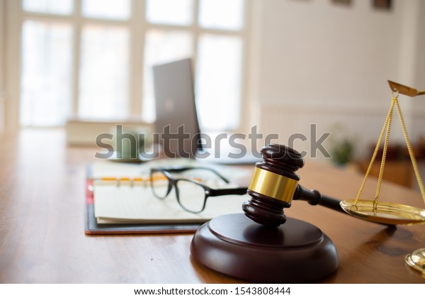 Justice law Scales and books and wooden\
gavel tool on desk in  Lawyer\
office.concept