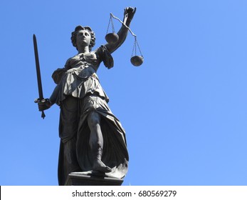 Justice Statue Over Blue Sky