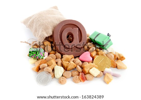 a jute bag full of pepernoten, a atpersand made of chocolate and a lot of candies on a white background