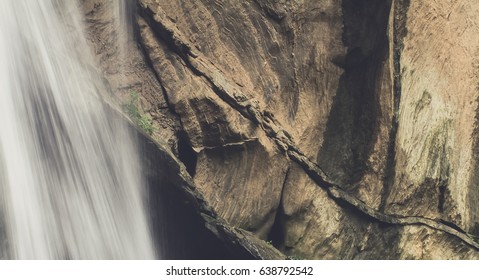 juxtaposition of wallterfall and mountain create contrast of material between water and rock - Powered by Shutterstock