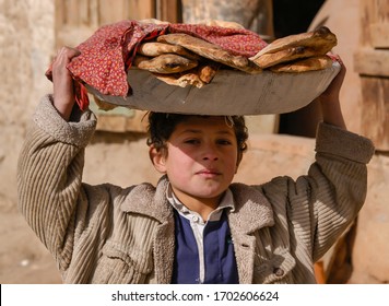 Kabul, Afghanistan - Dec 2003: Young Boy Carries Fresh-baked Bread