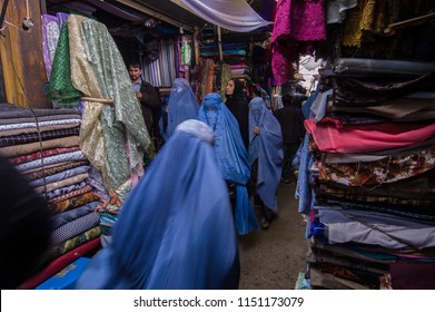 Kabul, Afghanistan, March 2005: Woman Looking At Cloth In Kabul Market Stall