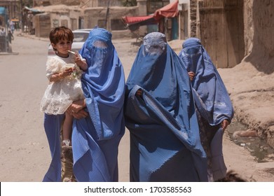 Kabul, Afghanistan - May 2004: Women In Burqas In Kabul Walking With A Child