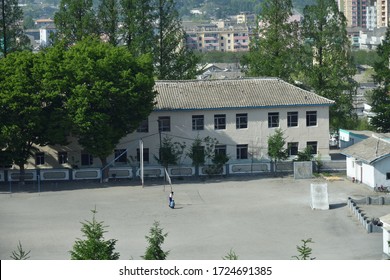 Kaesong, North Korea. School Yard. Guys Setting Volleyball Net On The Playground. View From Above