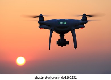 KAGAWA, JAPAN - JUNE 15, 2017: Remote controlled drone Dji Phantom 4 Pro equipped with high resolution video camera flying in air and sunset sky. 