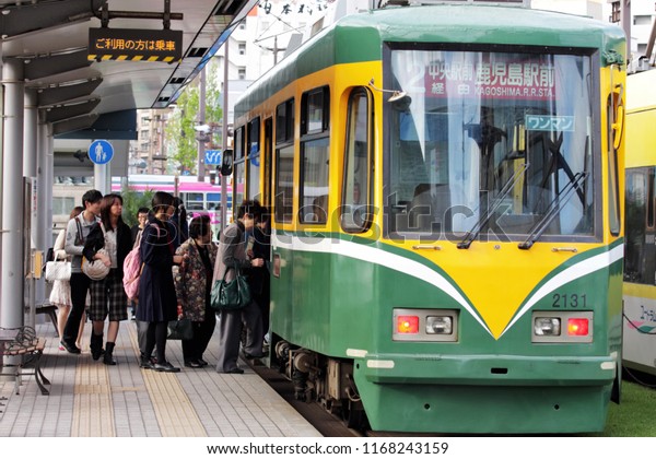 KAGOSHIMA, JAPAN - APRIL 10, 2010: People\
getting into tram number 2 at Kagoshima Central Station. Tram is\
run by Kagoshima City Transport Bureau and it is the cheapest way\
of moving around\
downtown