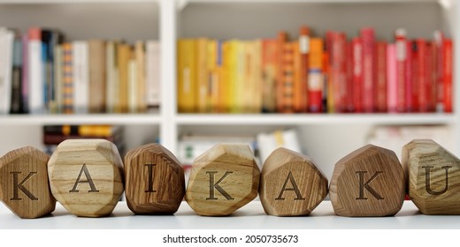 Kaikaku Word (Japanese Term For Radical Change) On Wooden Blocks On Table In Home Library, Blurred Books Background.