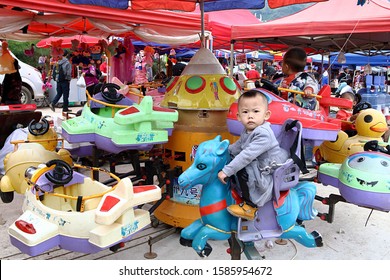 Kaili, China - October 24, 2019: At The Lusheng Festival Of Zhongan Town, A Baby Turns Into A Colored Carousel