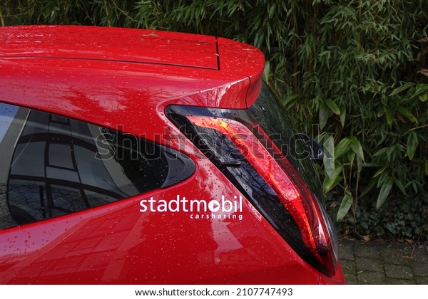Kaiserslautern,
Rhineland Palatinate, Germany, 09 January 2022, Back part of a red
Stadtmobil carsharing car with green bushes in the background,
green mobility (horizontal
image)