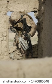 Kajaki, Afghanistan - April 22, 2012: US Marine Enters An Afghan Compound Through A Hole In The Wall.