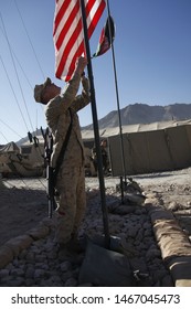 Kajaki, Afghanistan - March 20, 2012: US Marines Raise The American Flag Next To The Afghan Flag Upon A US Military Forward Operating Base. 