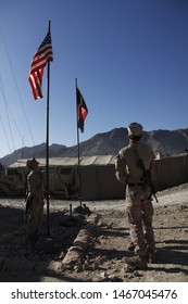 Kajaki, Afghanistan - March 20, 2012: US Marines Raise The American Flag Next To The Afghan Flag Upon A US Military Forward Operating Base. 