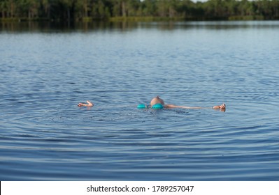 Kakerdaja / Estonia - August 01 2020: Teenager Blonde Girl Swimming In Bog Lake. Hands And Feet Spread Out. Human Body Floating In Pool. 